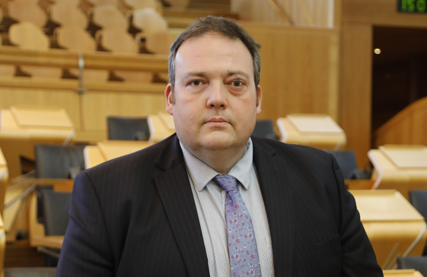 Jamie Halcro Johnston standing in Parliament